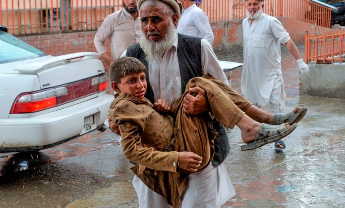 TOPSHOT - A volunteer carries an injured youth to hospital, following a bomb blast in Haska Mina district of Nangarhar Province on October 18, 2019. - At least 28 worshippers were killed and dozens wounded by a blast inside an Afghan mosque during Friday prayers on October 18, officials said, a day after the United Nations said violence in the country had reached "unacceptable" levels. (Photo by NOORULLAH SHIRZADA / AFP) (Photo by NOORULLAH SHIRZADA/AFP via Getty Images)