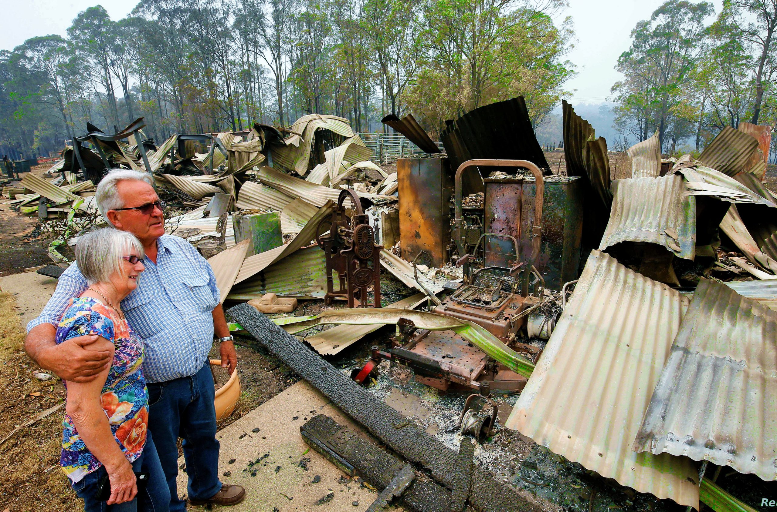 Lyn and Peter Iverson with their burnt out office and shed on their property at Half Chain road, Koorainghat, Australia, November 11, 2019. AAP Image/Darren Pateman/via REUTERS    ATTENTION EDITORS - THIS IMAGE WAS PROVIDED BY A THIRD PARTY. NO RESALES. NO ARCHIVE. AUSTRALIA OUT. NEW ZEALAND OUT.