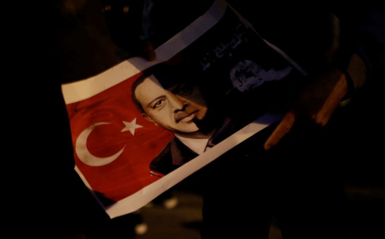 A Kurd living in Greece holds a poster depicting Turkish President Recep Tayyip Erdogan during a demonstration against the Turkish offensive on Kurdish forces in northwest Syria, in Athens, Greece, January 23, 2018. REUTERS/Alkis Konstantinidis - RC16FB9E79B0