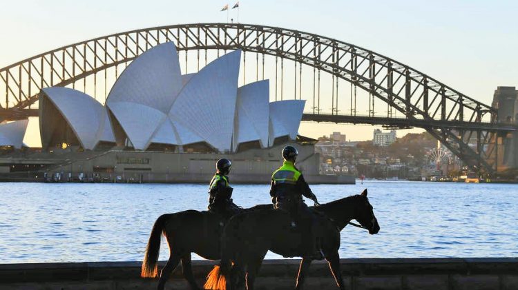 SYDNEY, AUSTRALIA - JULY 30: Two mounted police officers patrol around the edge of the harbour next to Mrs Macquarie's Chair on July 30, 2021 in Sydney, Australia. Covid-19 lockdown restrictions in hot spot local government areas have increased with masks required outdoors at all times and residents limited to movement within a 5 kilometre radius of their homes. Police have been given more authority to enforce public health orders with the help of the Australian Defence Force as Greater Sydney enters an extended lockdown through to August 28th in order to contain the highly contagious Covid-19 delta variant. (Photo by James D. Morgan/Getty Images)
