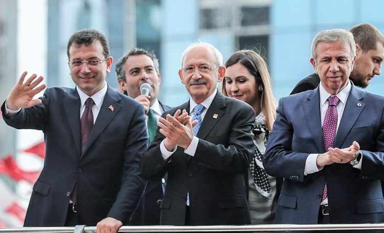 Turkey's main opposition Republican People's Party (CHP) leader Kemal Kilicdaroglu (C), Mansur Yavas (R) and Ekrem Imamoglu (L) who respectively claim mayoral elections victory in Ankara and Istanbul greet supporters in front of their party's headquarters on April 2, 2019 in Ankara. - Turkish President's AKP party appealed today against results in Istanbul and Ankara following a weekend election after tallies showed the ruling party lost both key cities. (Photo by Adem ALTAN / AFP)