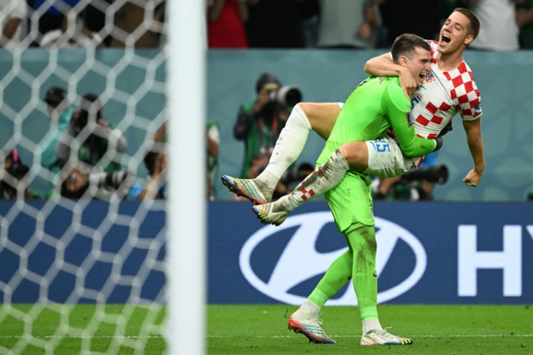 Croatia's goalkeeper #01 Dominik Livakovic celebrates with Croatia's midfielder #15 Mario Pasalic after winning the Qatar 2022 World Cup round of 16 football match between Japan and Croatia at the Al-Janoub Stadium in Al-Wakrah, south of Doha on December 5, 2022. (Photo by Ina Fassbender / AFP)